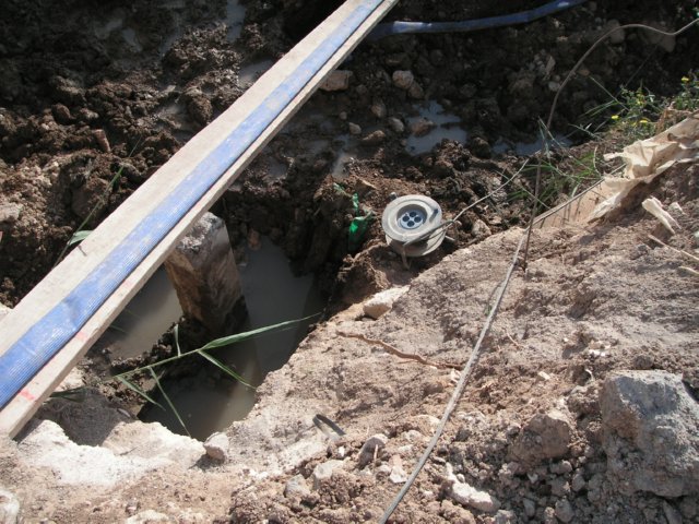 Tablón sobre una zanja con agua y bordes irregulares