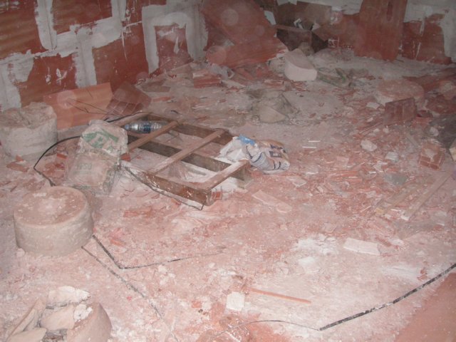 Escombros, palé y cables sobre un suelo interior