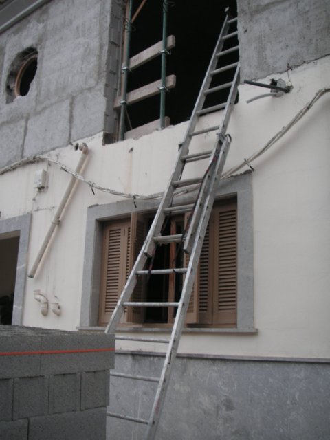 Escalera de mano apoyada ante un hueco de fachada