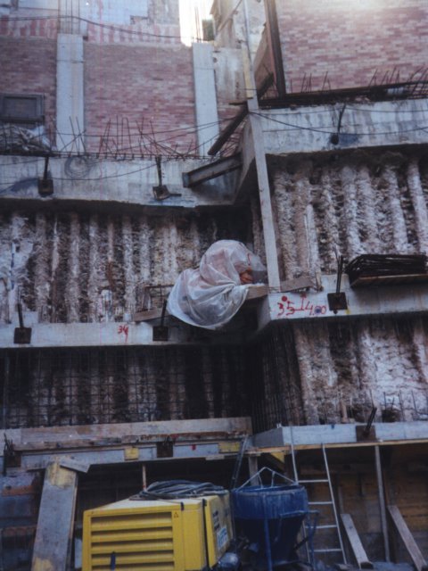 Encofrados y equipos acumulados en una obra entre edificios