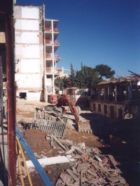 Excavadora y escombros en una demolición entre edificios