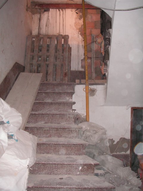 Escalera interior con palé y materiales en el desembarco