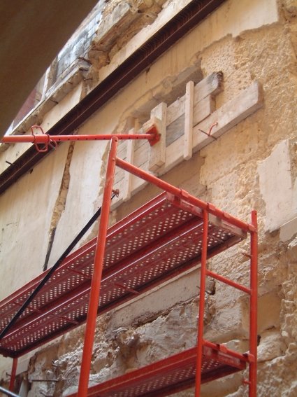 Andamio bajo un hueco de fachada apuntalado