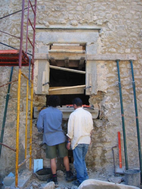 Personas ante un hueco de muro con apeos de madera